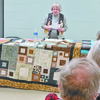 SUBMITTED PHOTOS
Jane Traver reads stories about the quilts displayed at a Truman Public Library event. Her presentation was called Quilt Stories with a Twist.